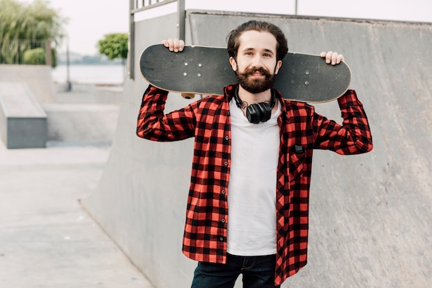 Man in skate park holding skateboard