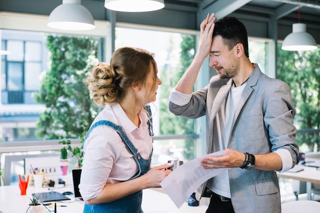 Man slapping forehead near woman