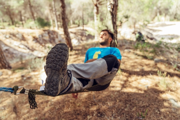 Man sleeping in hammock in forest
