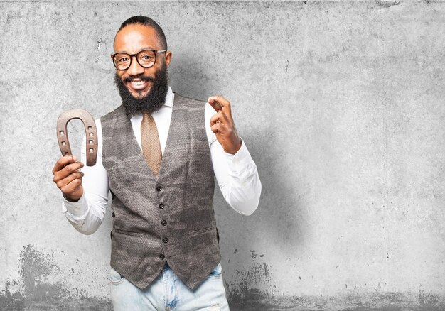 Man smiling holding a horseshoe and crossing his fingers