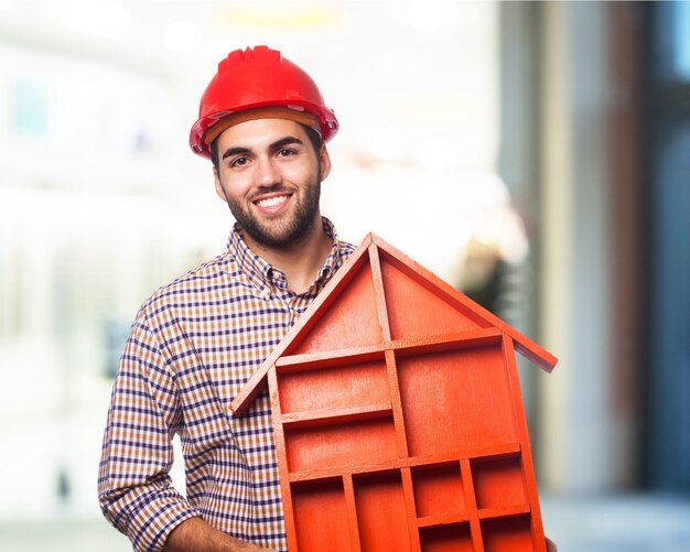 Man smiling holding a house