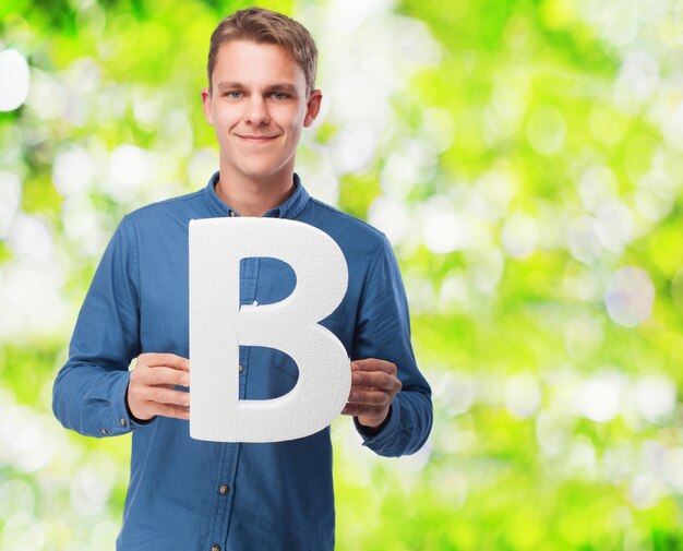 Man smiling holding the letter "b"