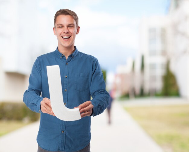 Man smiling holding the letter "l"