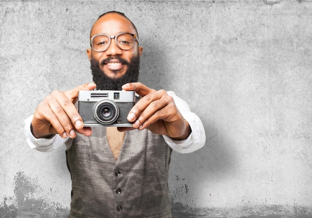 Uomo sorridente e in possesso di un vecchia macchina fotografica