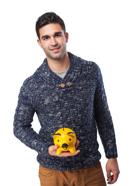 Man smiling holding a pig piggy bank