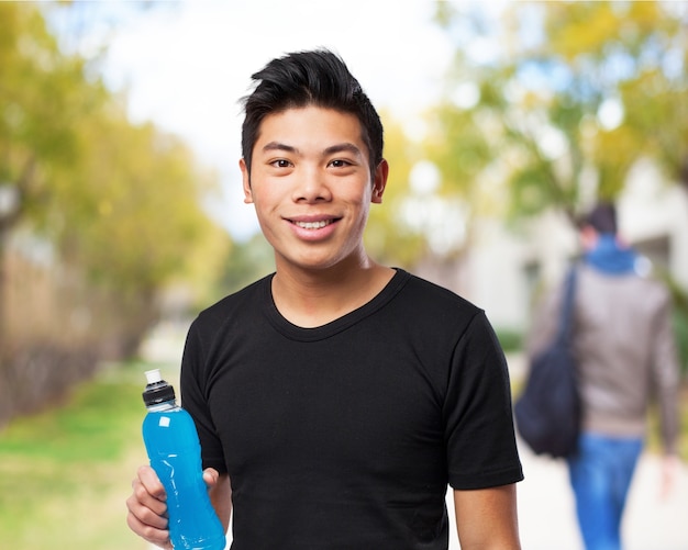 Man smiling with a bottle of drink