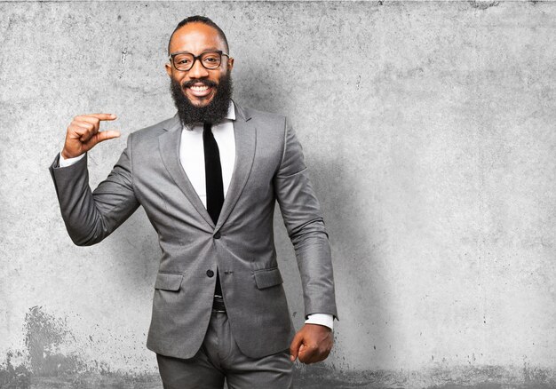 Man smiling with suit indicating a measurement with his fingers