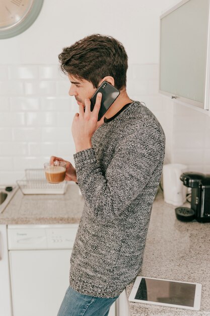Бесплатное фото Мужчина разговаривает по телефону и пил кофе