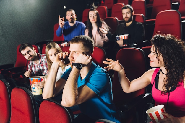 映画館で電話で話す男