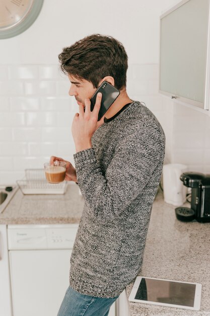 Man speaking on phone and drinking coffee