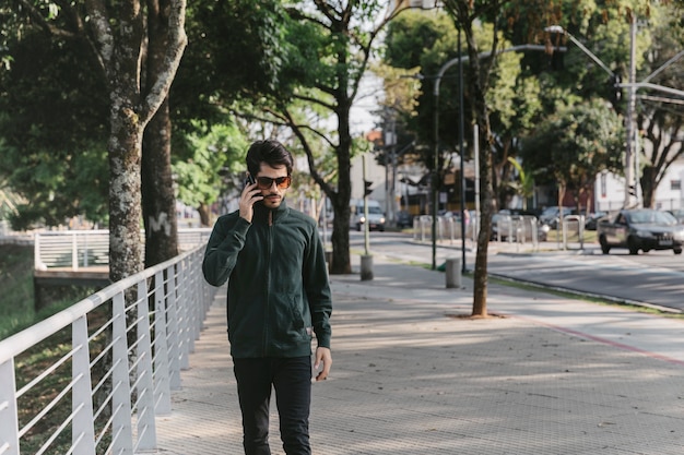 Man speaking on phone near fence