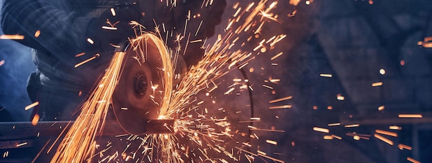 Man in special suit polishing metal with angle grinder