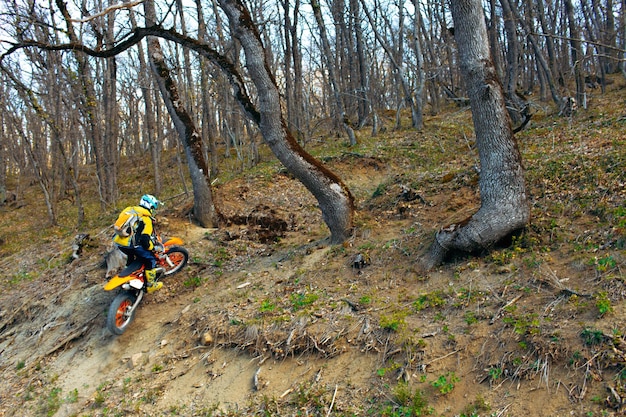 Man in sport equipment riding a motorcross bike in mountains