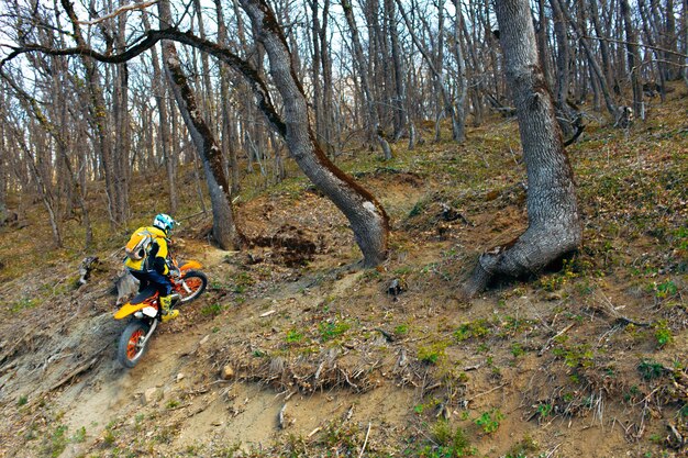 山でモトクロスバイクに乗るスポーツ用品の男