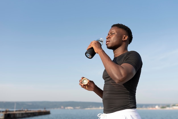 Man in sportswear holding a bottle of water