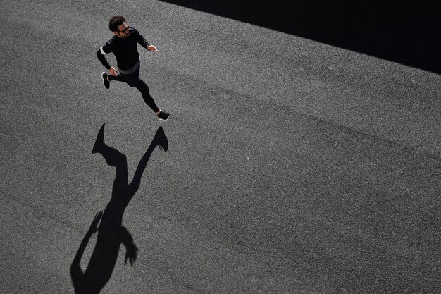 Man in sportswear running on road