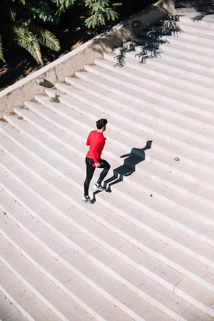 Man in sportswear running upstairs