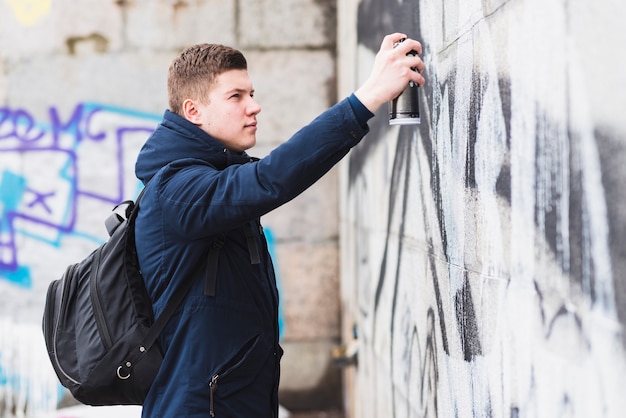 Man spray painting on wall