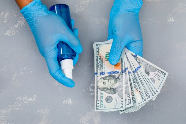 man spraying sanitizer on banknotes.