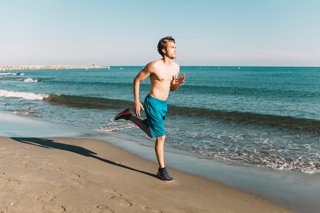 Человек бежит по пляжу
