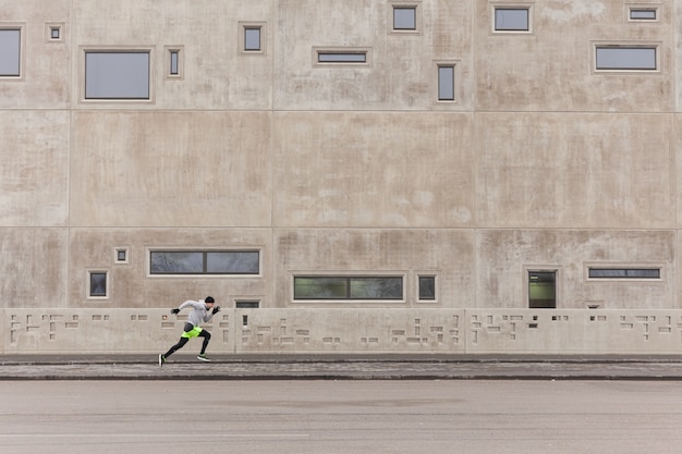 Free photo man sprinting in urban environment