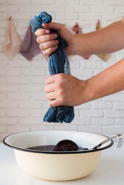 Man squeezing natural pigments out of cloth