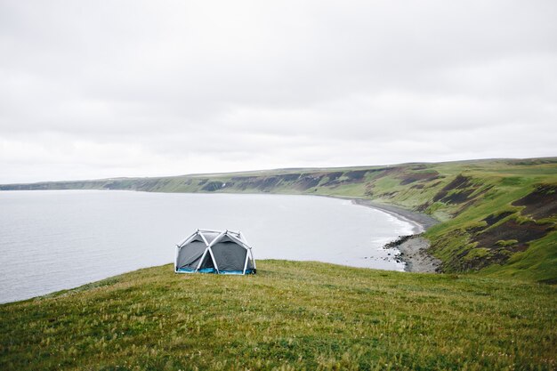 男はアイスランドのモダンなテントの隣に立つ