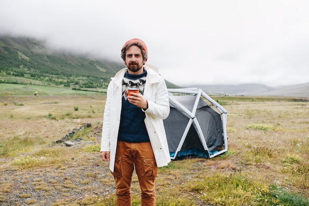 아이슬란드에있는 현대 텐트 옆에 서있는 남자