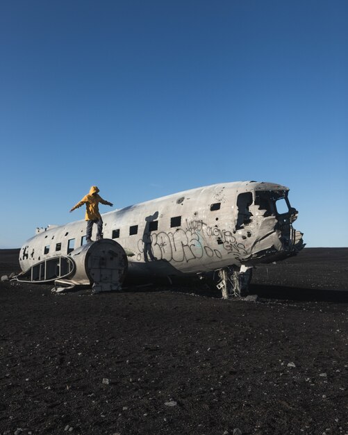 放棄された墜落した飛行機に立っている人