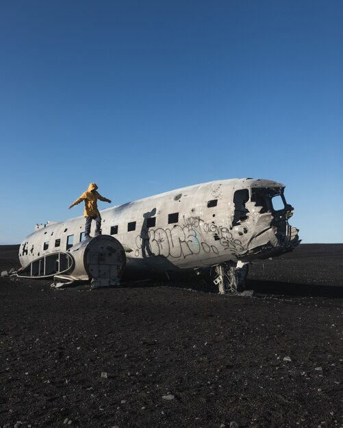 Человек, стоящий на заброшенном разбитом самолете