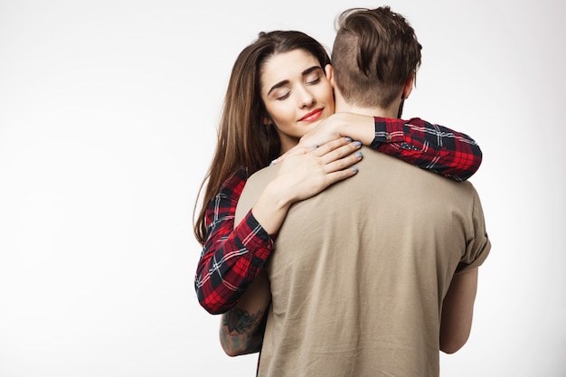 Free photo man standing backwards, womanfriend hugging him romantically