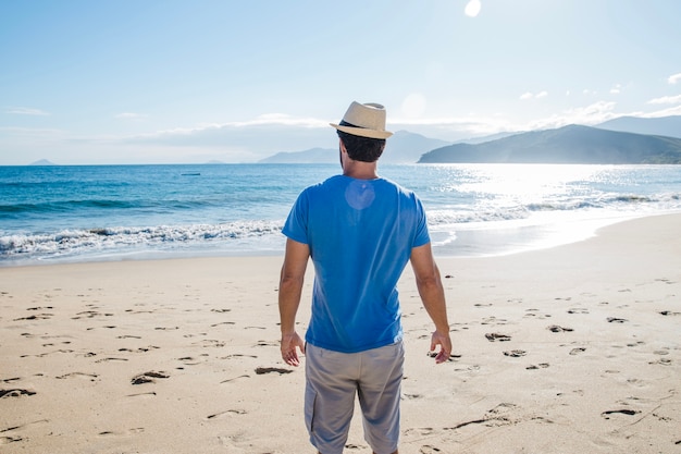 Foto gratuita uomo in piedi sulla spiaggia