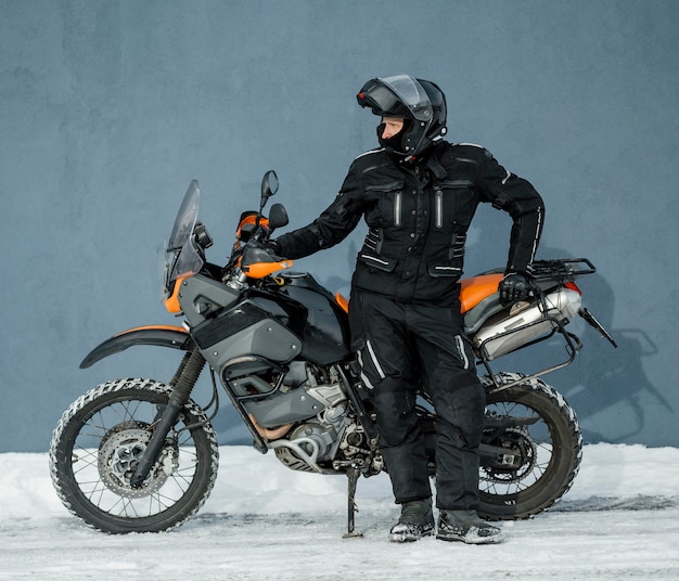 Человек, стоящий рядом с мотоциклом в шлеме