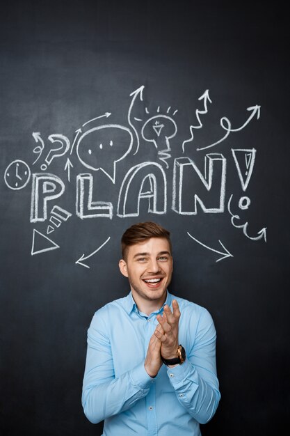 Man standing over blackboard with a plan concept applause