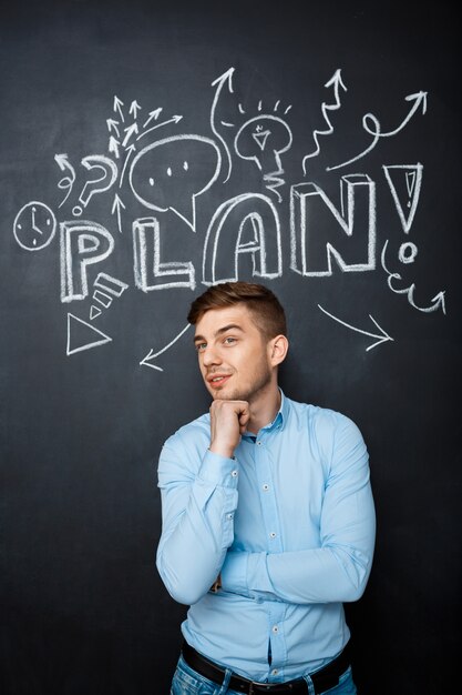 Man standing over blackboard with a plan concept