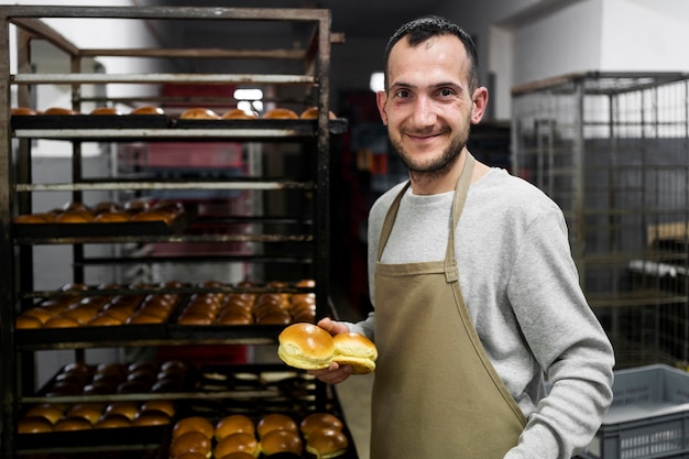 Free photo man standing in a bread bakery