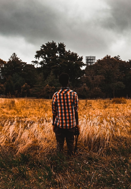 Free photo man standing on brown field