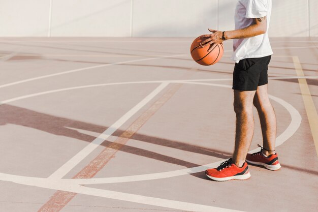 Man standing in court holding basketball