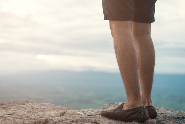 Man standing on edge of a cliff mountain top , travel concept.