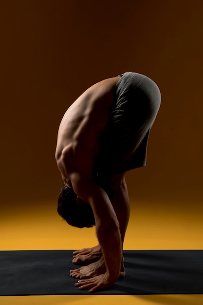 Free photo man standing in forward bend pose