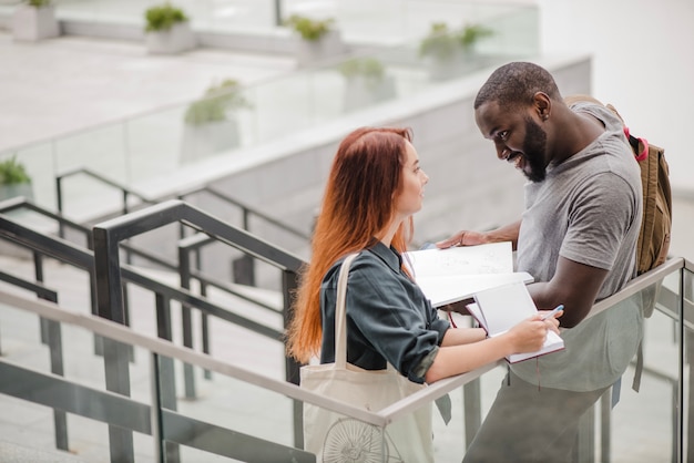 Free photo man standing and helping woman with docs