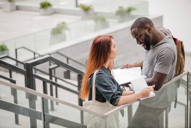 Man standing and helping woman with docs