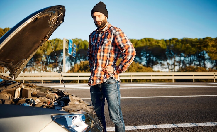 Free Photo man standing next to his broken car