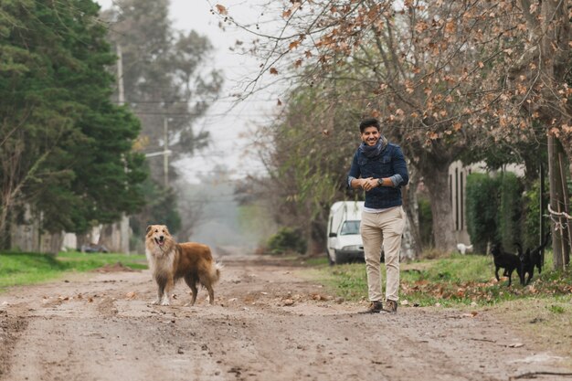 Man standing and his dog standing on dirt track