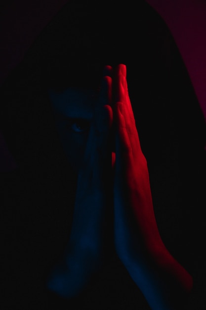 Бесплатное фото Человек, стоящий в тени и молящийся