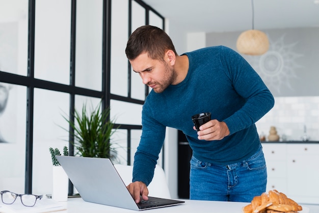 Man standing looking at laptop