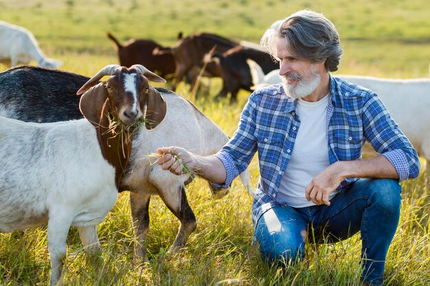 Man standing in the middle of goats