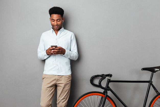 Man standing near bicycle chatting by phone.