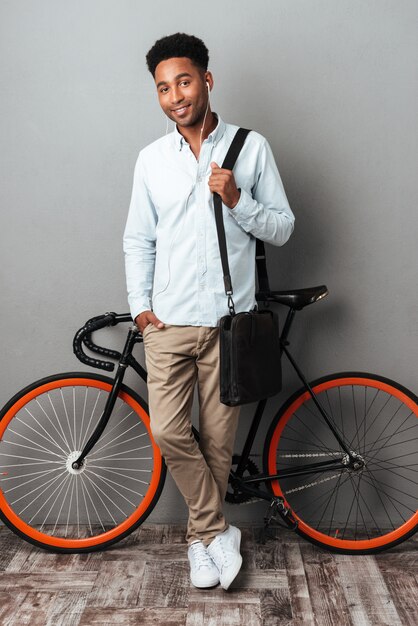 Man standing near bicycle isolated over gray background