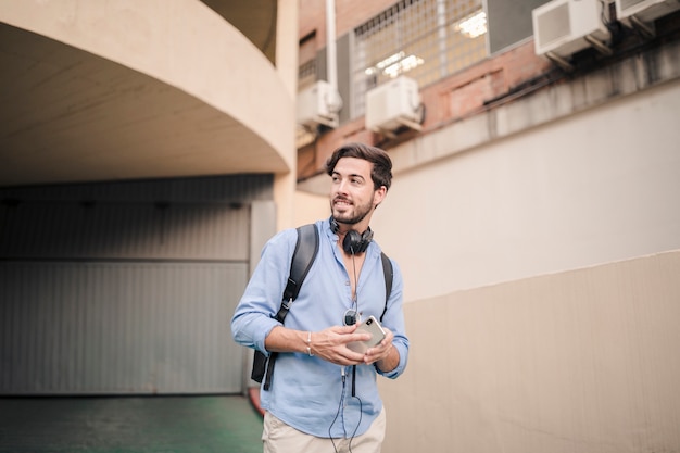 Foto gratuita uomo in piedi vicino edificio guardando lontano